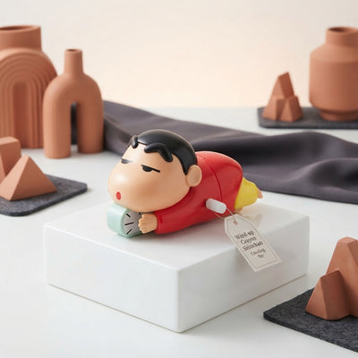 A Shinchan crawling toy displayed on a clean white surface with elegant terracotta and charcoal home decor accents.
